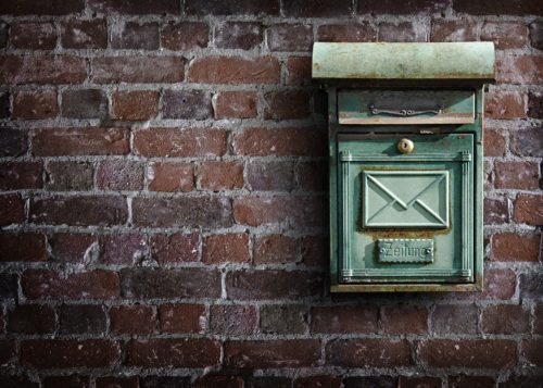 Vintage green mailbox with the word 'zeitung' affixed on a weathered brick wall, evoking the charm of old-fashioned correspondence, reminiscent of times when letters might have contained decisions about permanent al