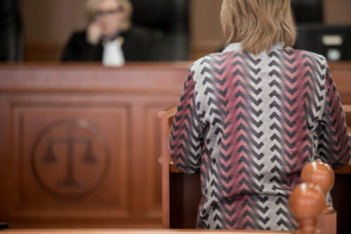 A divorce lawyer in Smithtown sitting in a courtroom, facing the judge's bench adorned with the scales of justice emblem.