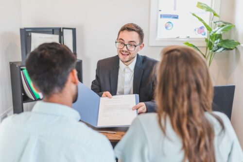 couple sitting at table with man holding document