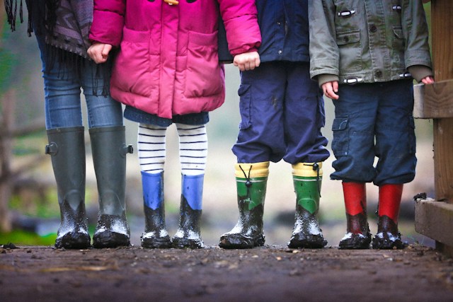 children standing with rainboots on