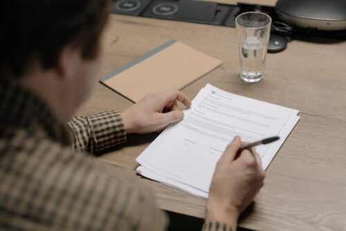 man signing paper