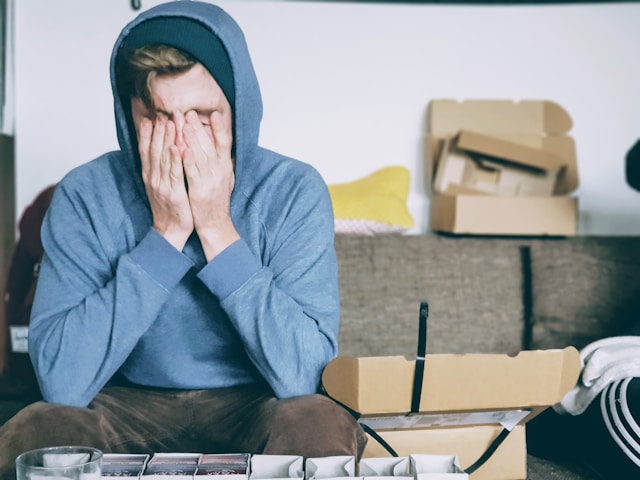 teen sitting with hands over face